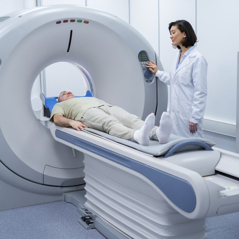 Radiologist preparing a patient for a DEXA/CT scan to assess hip bone density.