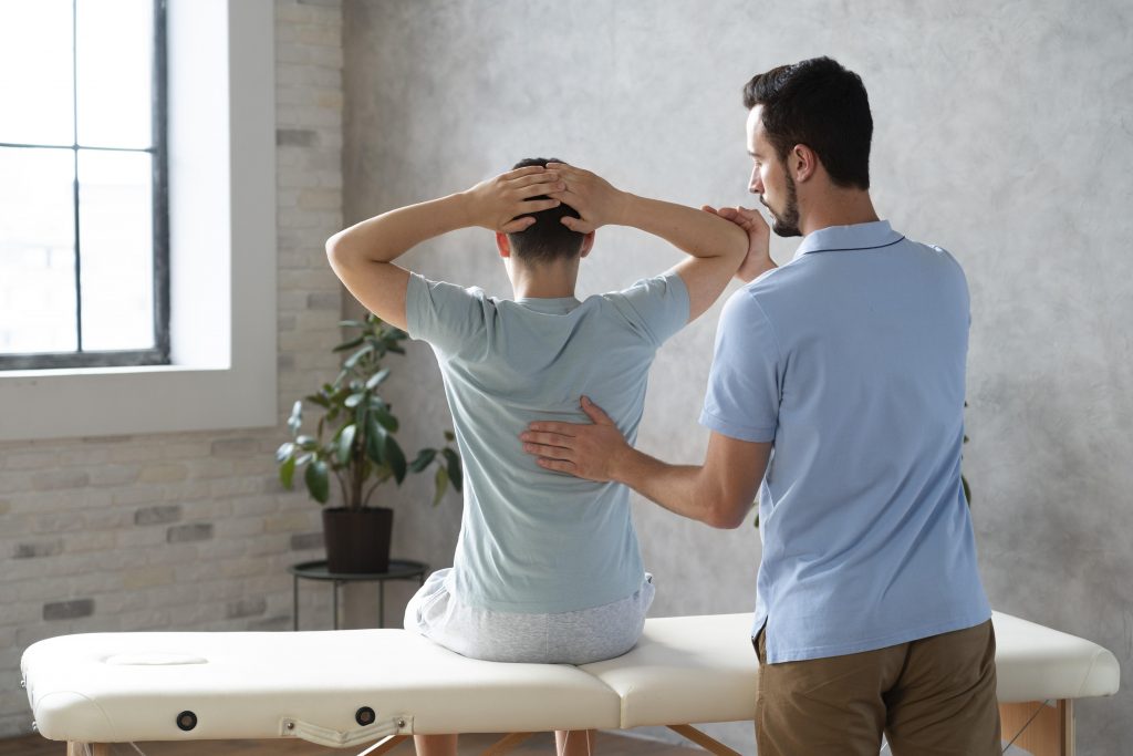 Physiotherapist helping a patient with back exercises.