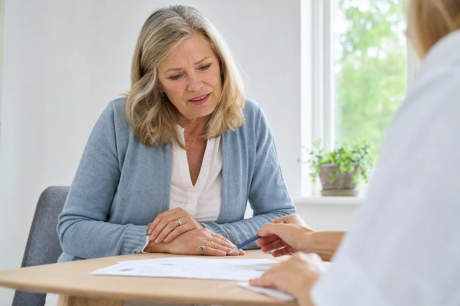 Illustration of an older woman discussing a bone density report with a healthcare professional.